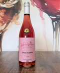 Bottle of Otters Plunder 2024 wine on a wooden surface with a colourful abstract background