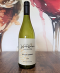 Wine bottle labelled 'Sozzled Squirrel 2023' on a wooden surface with a colourful abstract background