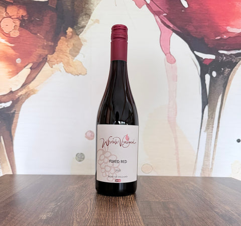 Bottle of Foxed Red 2025 English Pinot Noir from Wressle Vineyard, North Lincolnshire, with a cream label and burgundy cap, standing on a wooden table