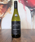 Wine bottle labelled 'Hammered Heron 2024' on a wooden surface with a colourful abstract background