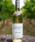 A bottle of Wressle Vineyard Giddy Goose 2025 white wine stands on a metal patio table with a blurred vineyard background.