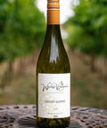 A bottle of Wressle Vineyard Sozzled Squirrel 2025 wine standing on a decorative metal table with a blurred vineyard background.